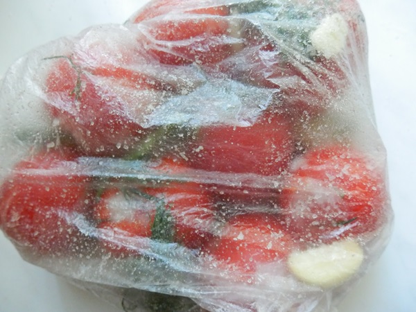 Vers gezouten tomaten in een zak en een pan