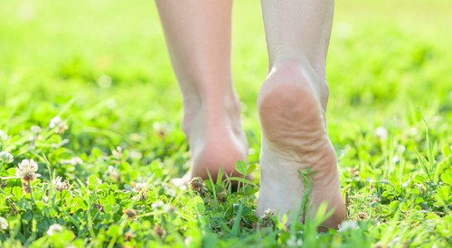 de vrouw loopt zonder schoenen op het gras